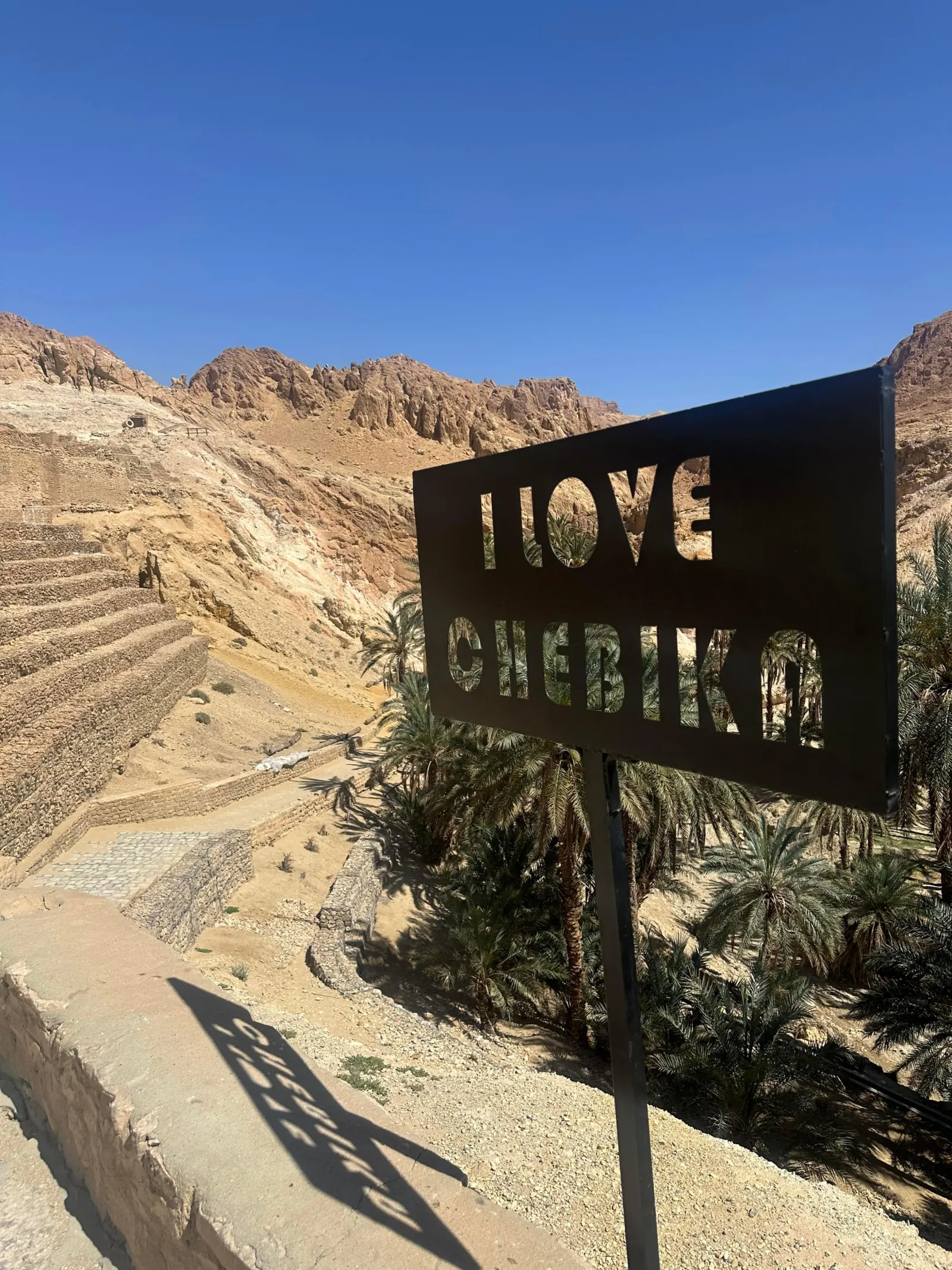 The 'I love Chebika' sign above the oasis