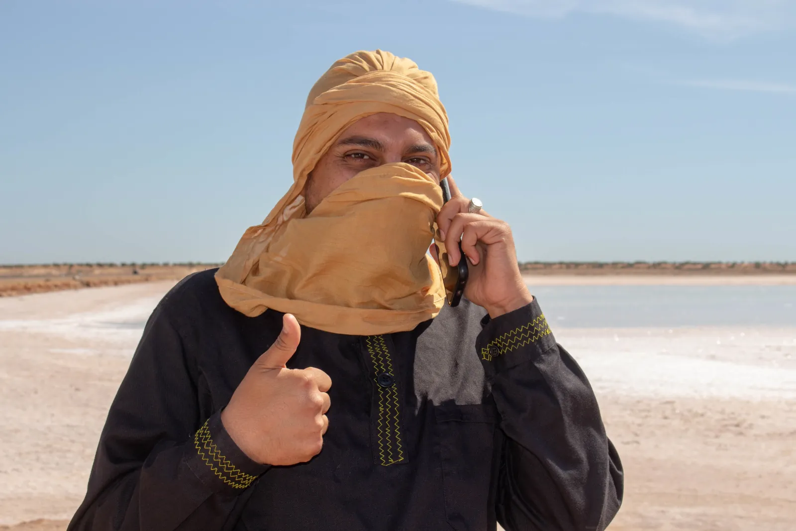 A guide in a desert shesh at the edge of the salt flats