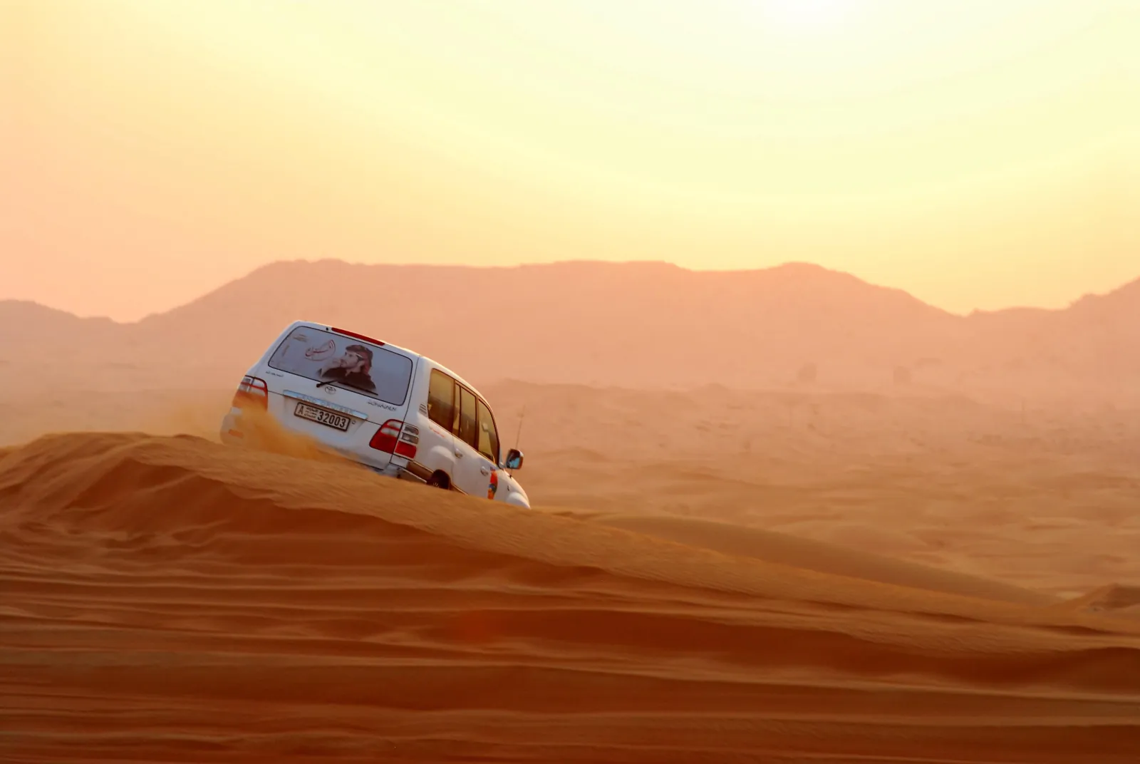 A 4x4 climbing a steep dune on the run towards Ksar Ghilane